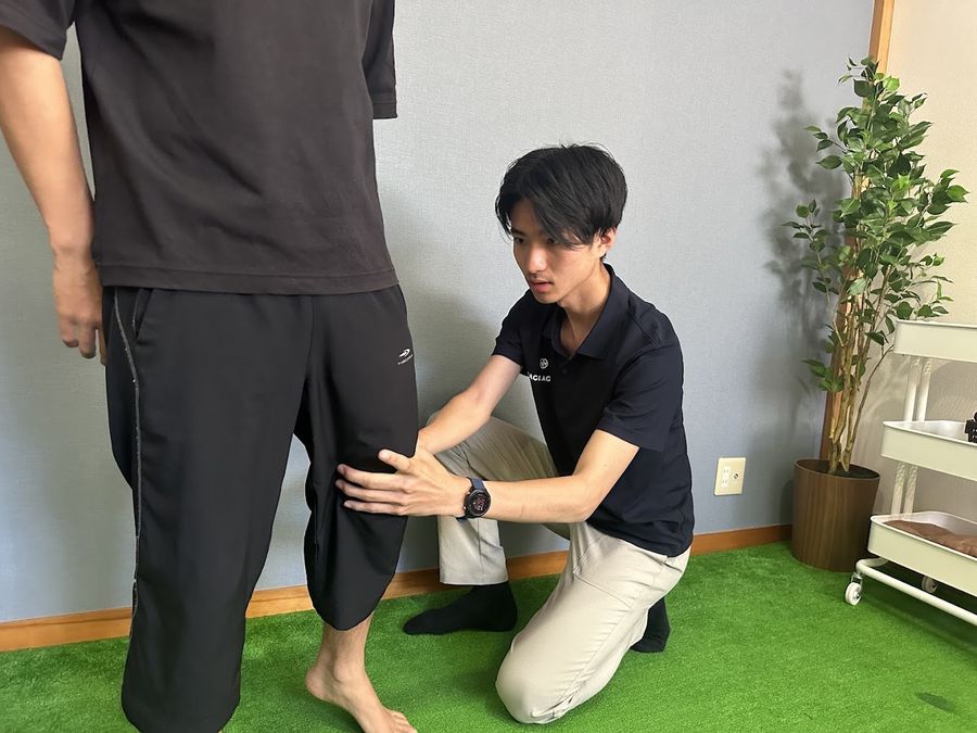 立った姿勢で、トレーナーが脚の動きを1対1で確かめている様子
